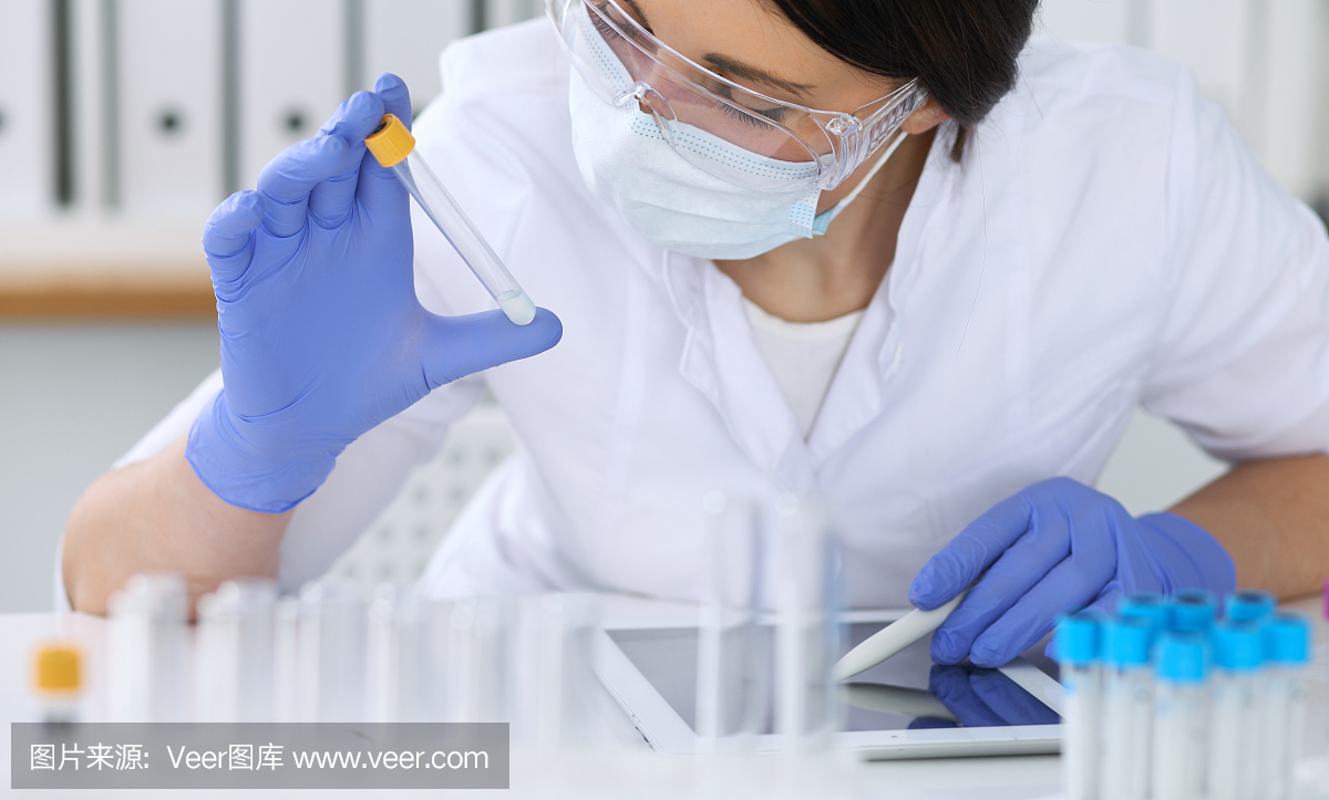 特写的专业女科学家在保护眼镜制作实验试剂在实验室。医学和研究概念