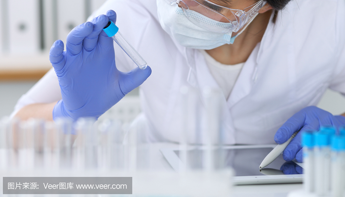 特写的专业女科学家在保护眼镜制作实验试剂在实验室。医学和研究概念